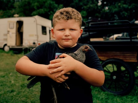 James, a young boy, is clutching a bird to his chest.