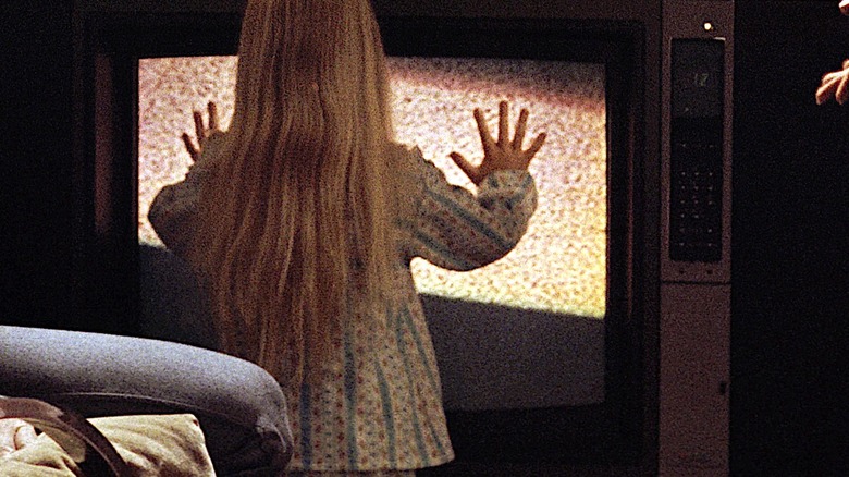 Heather O'Rourke as Carol Anne touching the TV emitting static in Poltergeist