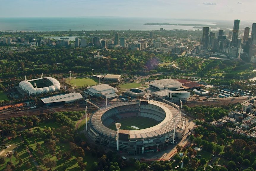 An aerial shot of a cricket stadium in a city.