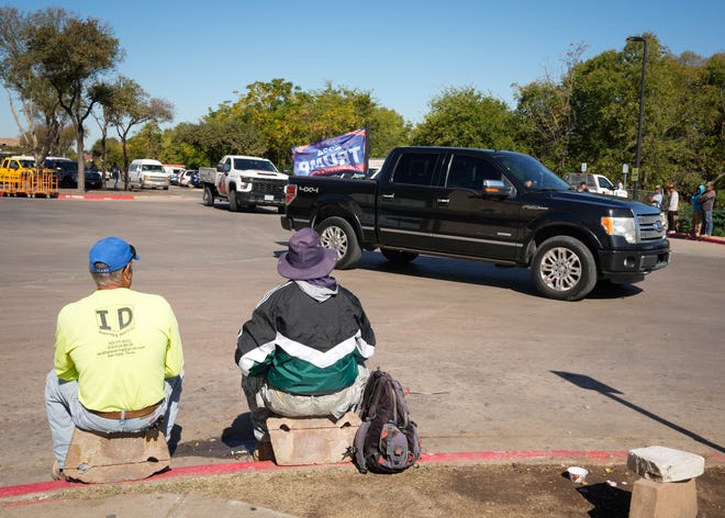 A Trump supporter drives past undocumented immigrants who were waiting for day labor jobs at a Home Depot in South Austin Wednesday November 6, 2024.