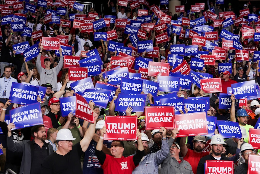 A crowd of Donald Trump supporters hold up signs in support of the Republican presidential nominee.