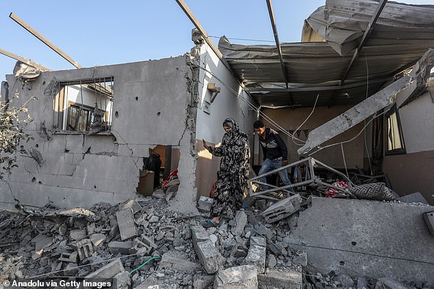 Palestinians try to salvage items from the rubble of a house damaged aftermath of an Israeli attack in Khan Younis city, southern Gaza, on November 6, 2024