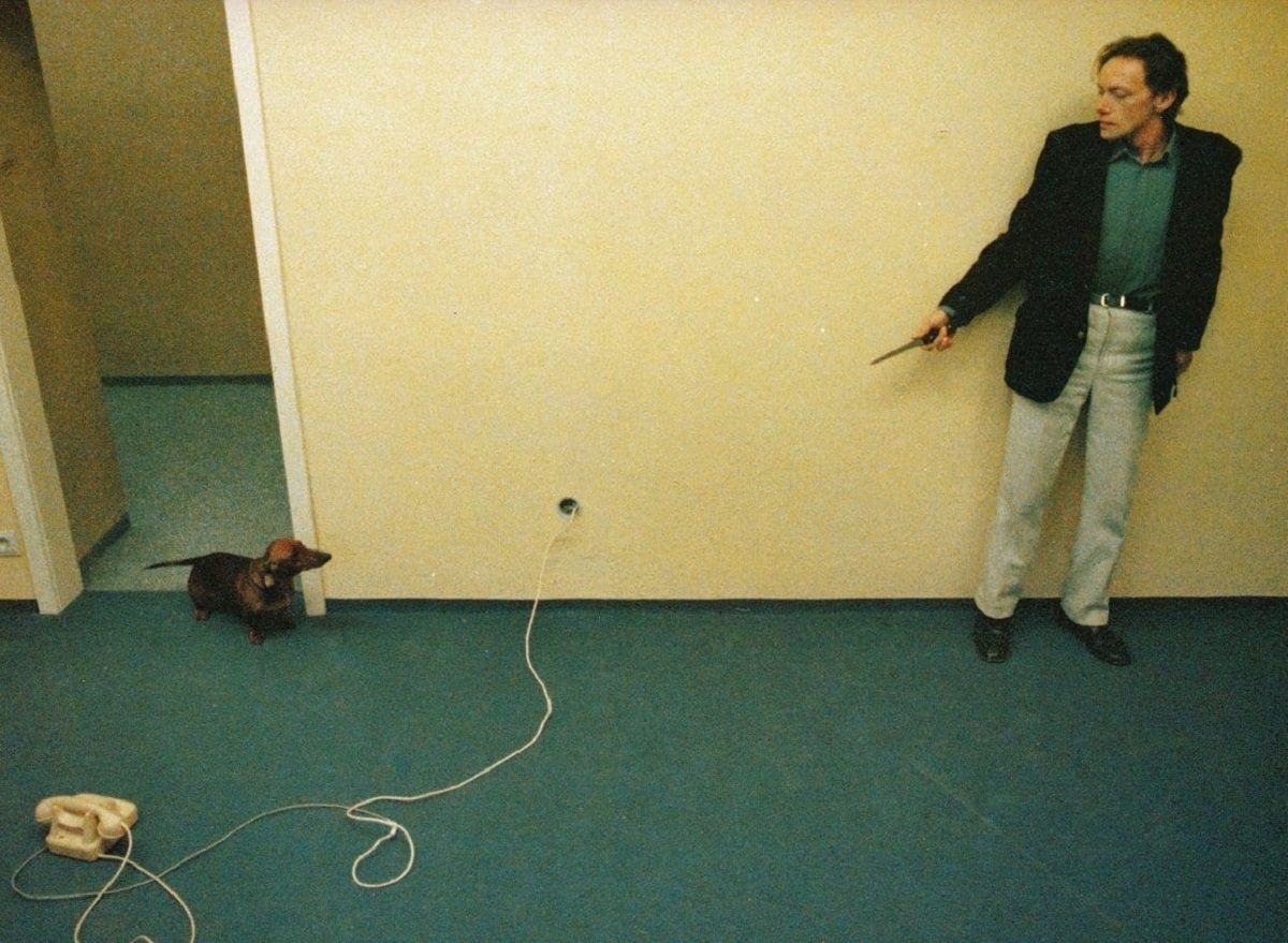 A psychopathic white male killer (Erwin Leder) brandishes a blade at a small dog that threatens to alert its owners of the intrusion in “Angst.” 