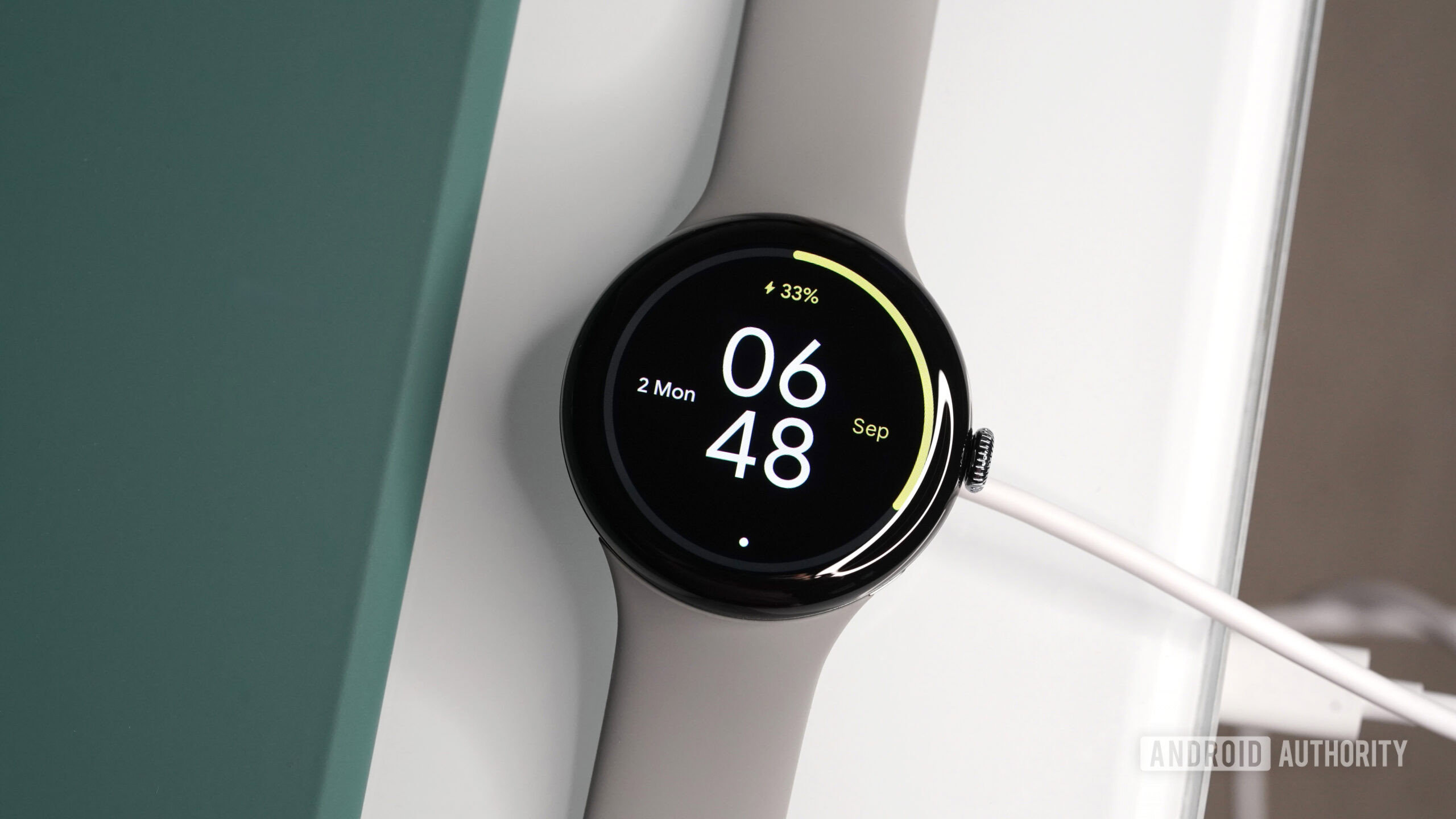 A Google Pixel Watch 3 rests on its charger.