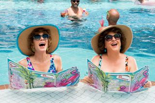 two women sitting in the pool with matching hats and swim suits in Barb and star