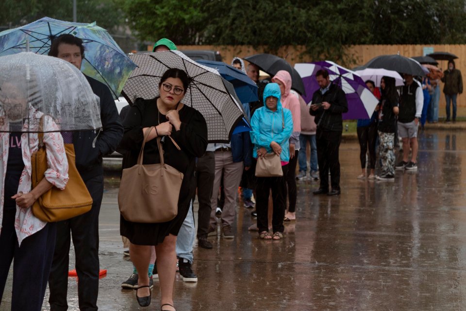 Voters battle heavy rain while waiting in line to vote at the Metropolitan Multi-Service Center in Houston