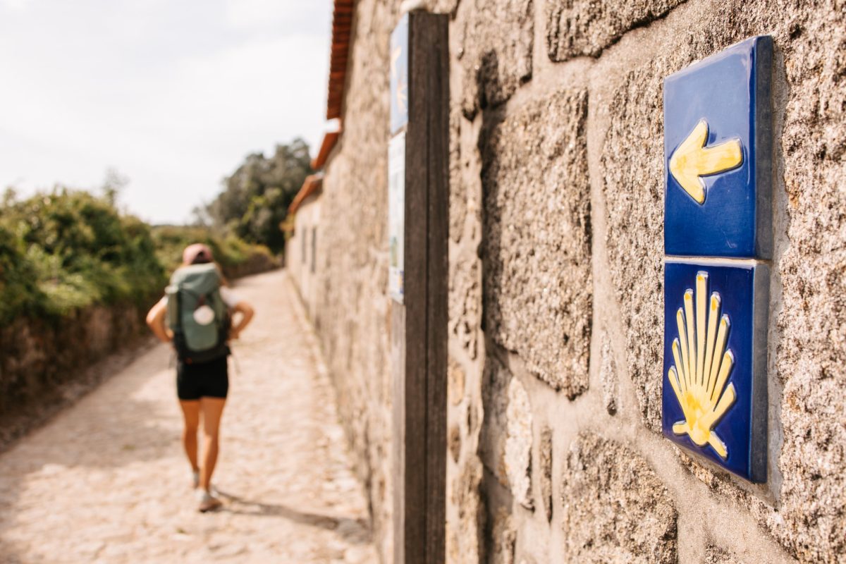 Camino de Santiago directional sign and a walking pilgrim