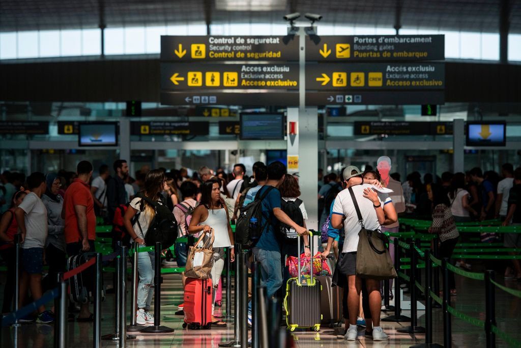 Passengers queue for passing the security control at Barcelona's El Prat airport on August 11, 2017. - Spain today called in police to help with security checks at Barcelona's busy airport as a strike continues at the peak of the holiday season, causing long queues and safety concerns. (Photo by Josep LAGO / AFP) (Photo credit should read JOSEP LAGO/AFP via Getty Images)