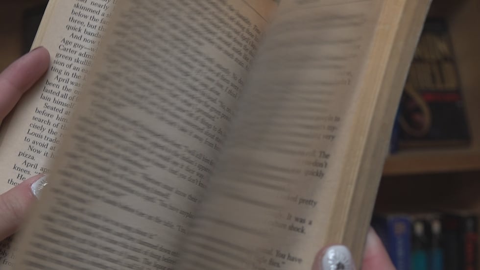 Patron flipping through the pages of book.