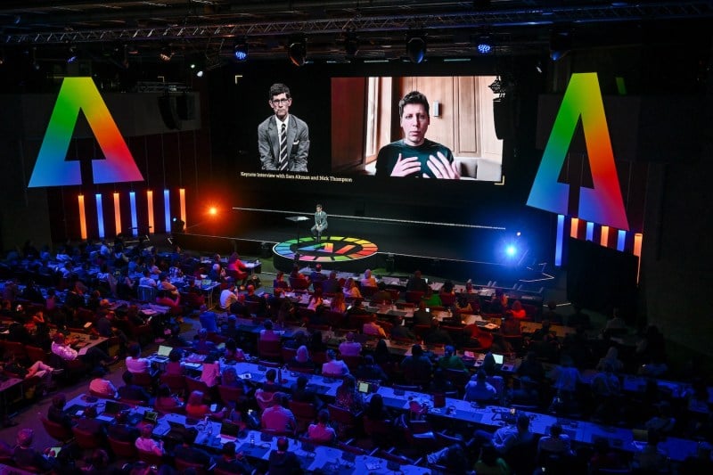 OpenAI CEO Sam Altman (R) appears on a giant screen speaking remotely during a keynote with Nicholas Thompson, CEO of The Atlantic during the International Telecommunication Union (ITU) AI for Good Global Summit, in Geneva, on May 30.