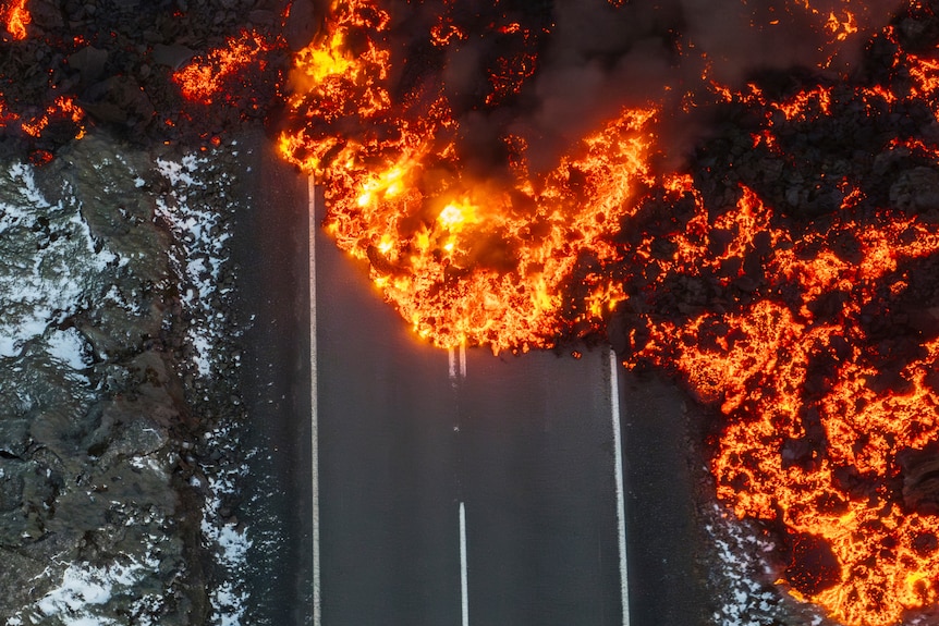 A bird's eye view of molten lava spilling onto an icy road. 