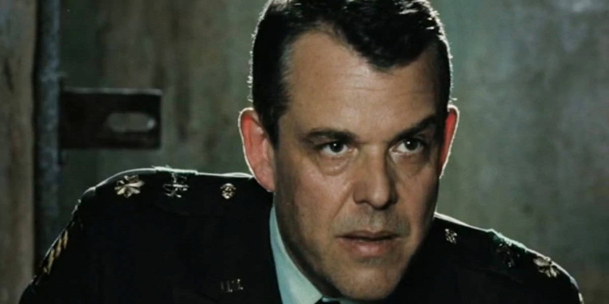 William Stryker (Danny Huston) in a military uniform, leaning forward in 'X-Men Origins: Wolverine'