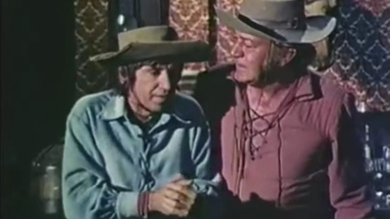 Dusty and a cowboy, with Dusty's hands tied.