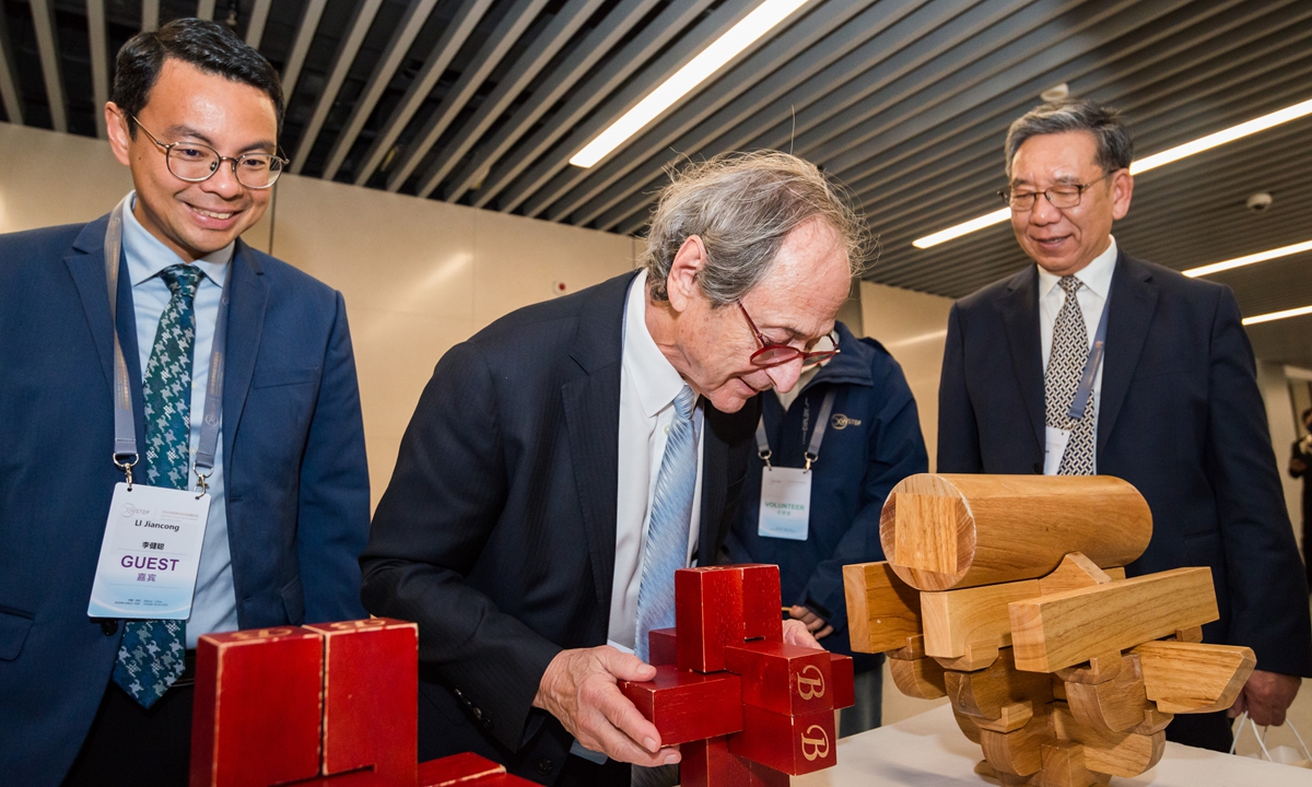 A foreign scientist (center) plays a Luban lock, a traditional Chinese folk educational toy, during the opening ceremony of the WSTDF 2024 on October 22, 2024. Photo: Chen Tao/GT