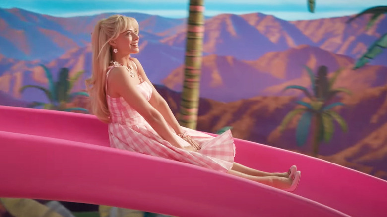 Margot Robbie going down the Dream House slide in Barbie