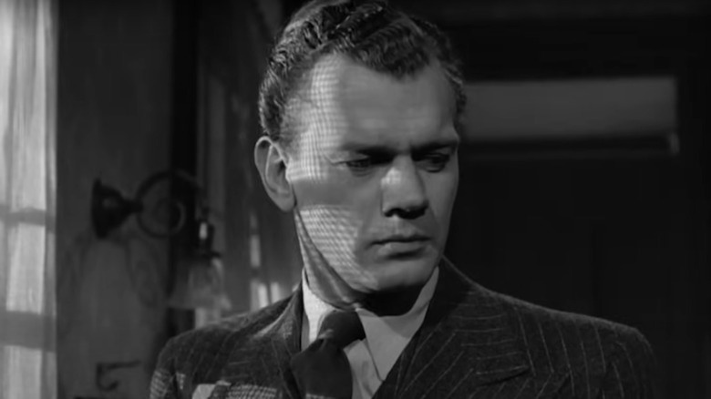 Joseph Cotten sinisterly lit through a drape in Shadow of a Doubt