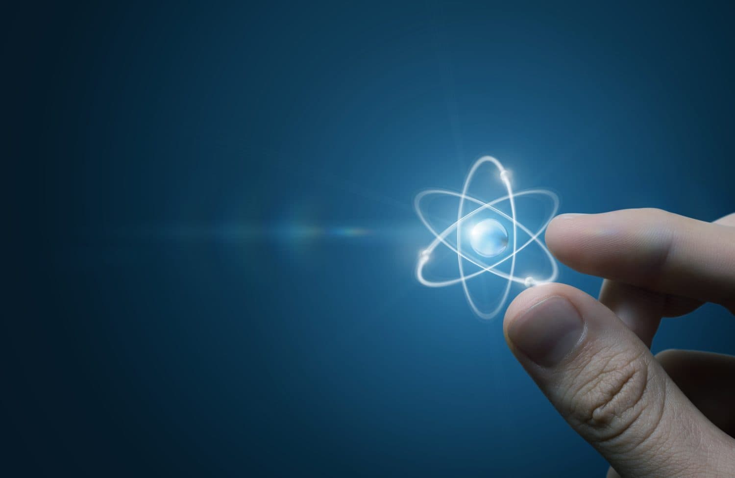 Fingers touching an atom on a blue background.