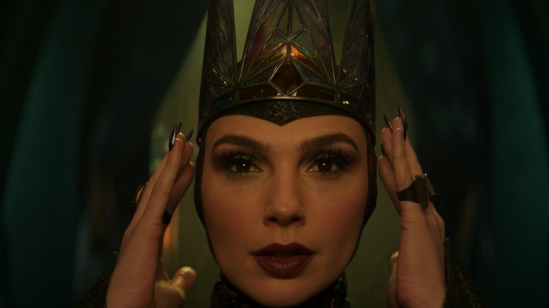 Gal Gadot as the Evil Queen putting on her crown in Snow White (2025)