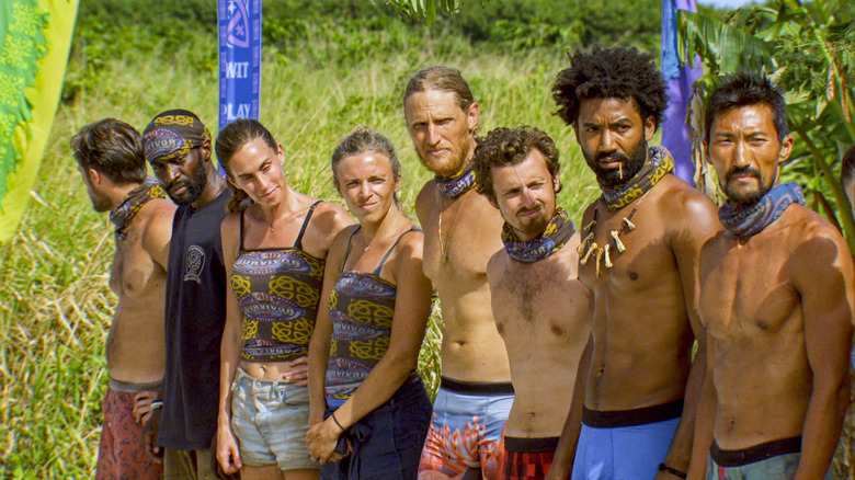 The cast of 'Survivor,' in scanty castaway-type clothing, standing in a line.