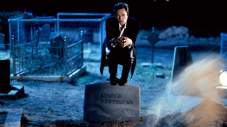 Gabriel perches on a tombstone in a cemetery in The Prophecy