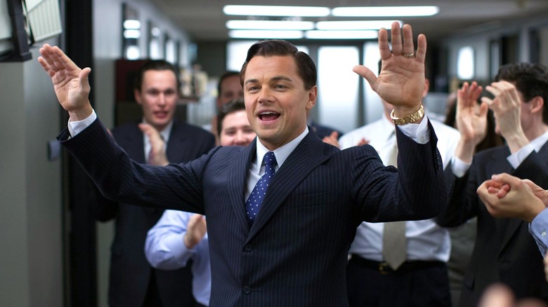 Jordan Belfort raising his arms in The Wolf of Wall Street