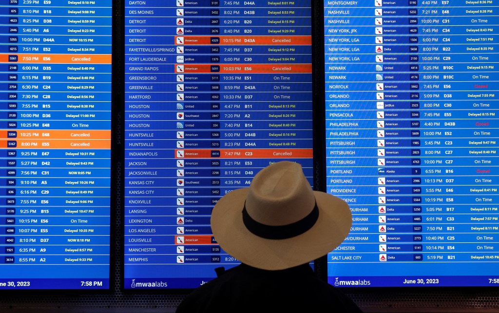 Travelers check the status of their flights ahead of the July 4th holiday weekend at Ronald Reagan Washington National Airport in Arlington, Virginia, U.S., June 30, 2023.