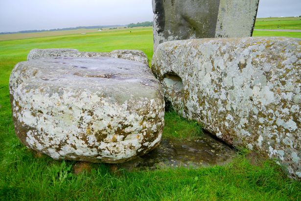 The Altar Stone at Stonehenge seen underneath two bigger stones