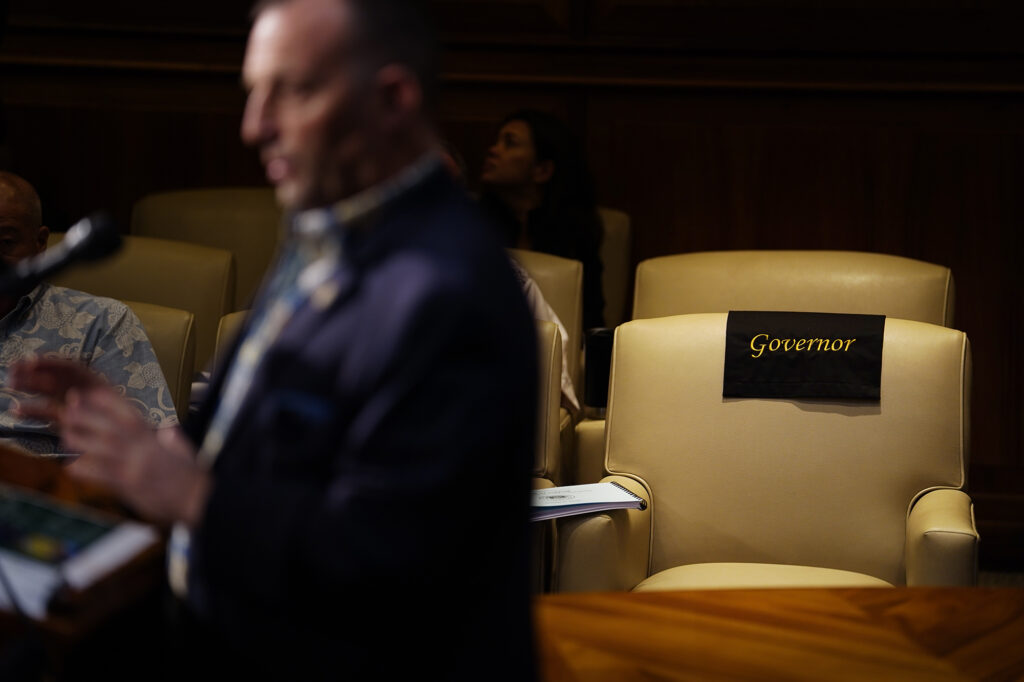 Gov. Josh Green empty seat is photographed during his announcement of the Executive Biennium Budget for Fiscal Years 2025-2027 to the Legislature Monday, Dec. 16, 2024, in Honolulu. (Kevin Fujii/Civil Beat/2024)