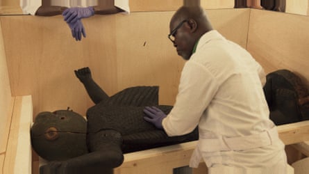 A museum attendant in Benin with a returned sculpture