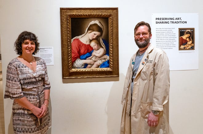 Clowes Conservator of Paintings Roxy Sperber, left, and Senior Conservation Scientist Greg Smith stand beside the Madonna and Child oil painting, from the 1600s, from the Workshop of Sassoferrato (Giovanni Batissta Salvi), Tuesday, Dec. 10, 2024 at the Indianapolis Museum of Art at Newfields. This painting was conserved and has been chosen as one of the images included in this year’s winter holidays’ collection of postage stamps at the United Postal Service.