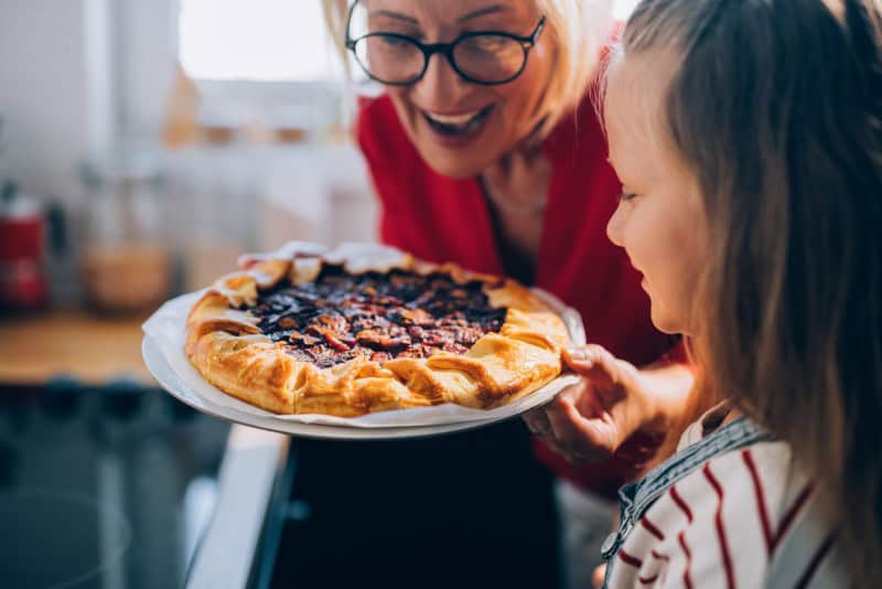 A grandmother making pie with her granddaughter. Making a pie chart out of pie is one of the activities