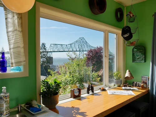 large kitchen with with a view of a large truss bridge in the background