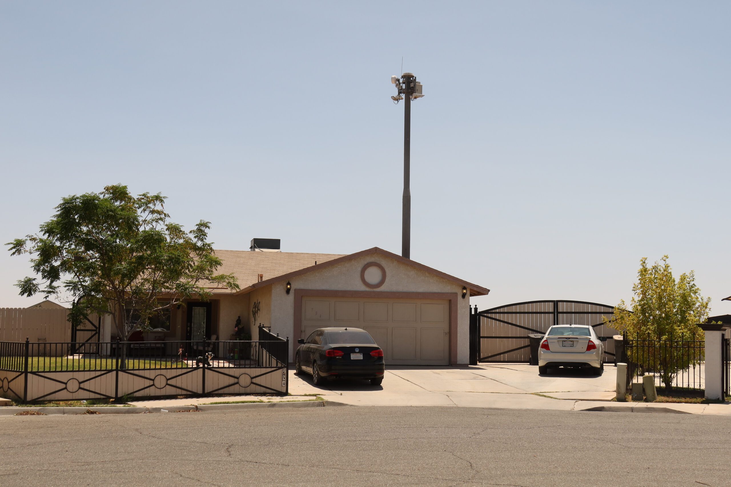 A surveillance tower over a one-story home. 