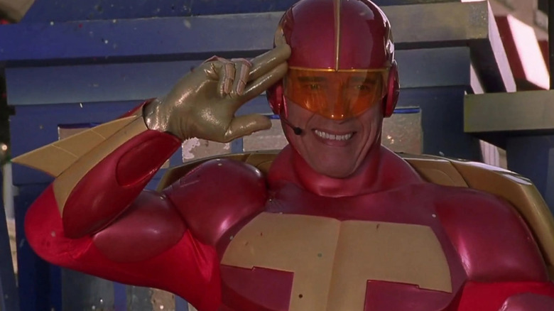 Arnold Schwarzenegger's Howard Langston salutes a parade while dressed as Turbo Man