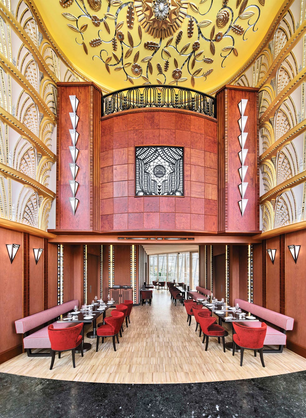 rendering of an art deco restaurant interior featuring elegant decor and seating arrangements with banquettes and red velvet chairs