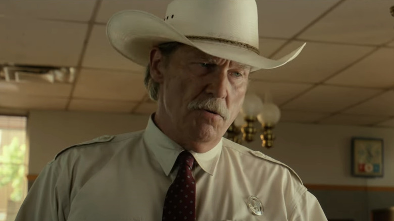 Jeff Bridges' Texas Ranger Marcus Hamilton wears a hat and looks down in a diner in Hell or High Water