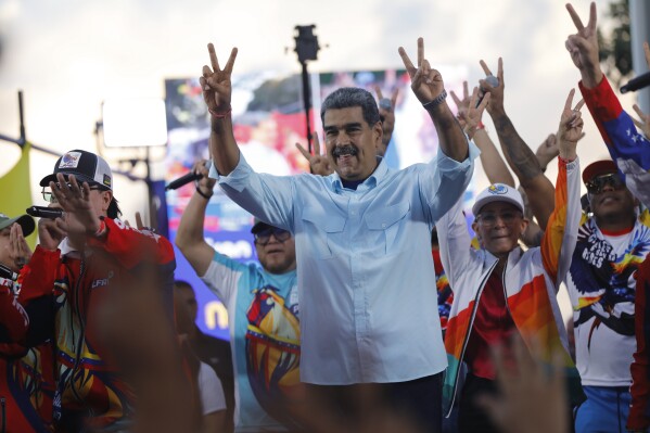 Venezuelan President Nicolas Maduro flashes victory hand signs at supporters during a pro-government rally, in Caracas, Venezuela, Aug. 17, 2024. (AP Photo/Cristian Hernandez, File)