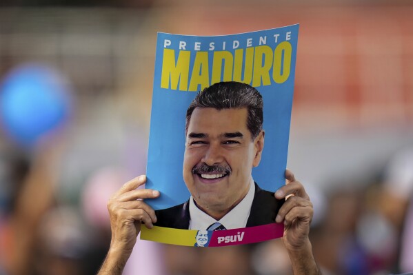 A supporter displays a poster of President Nicolas Maduro during his closing election campaign rally in Caracas, Venezuela, July 25, 2024. (AP Photo/Fernando Vergara, File)