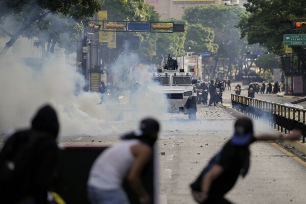 Protesters clash with police during demonstrations against the official election results declaring President Nicolas Maduro's reelection, the day after the vote in Caracas, Venezuela, July 29, 2024. (AP Photo/Matias Delacroix, File)