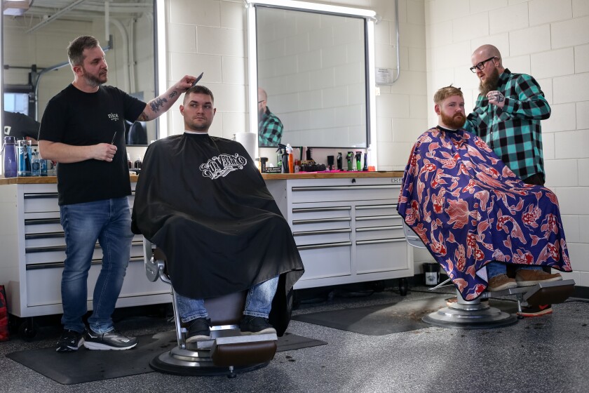 Scott Ehresman, left, and Jacob Johnson cut Troy Steele and Alex Gruver's hair on Monday, Jan. 6, 2025, at Nice Barber in north Fargo. 