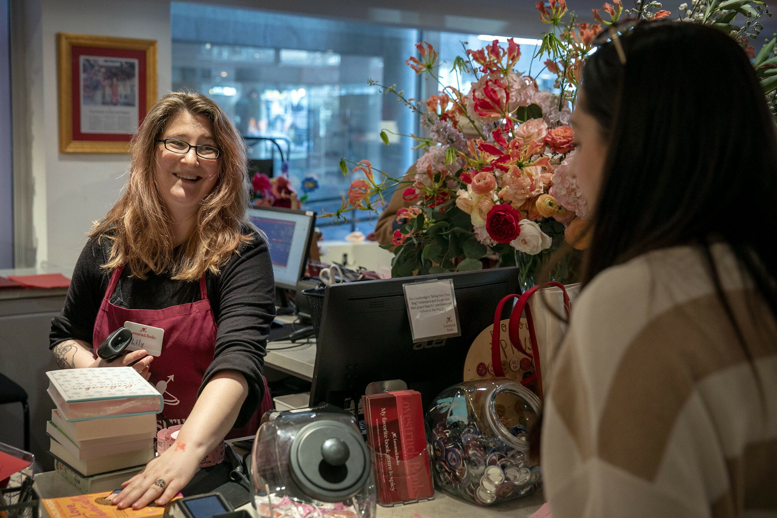 Bookseller Lily Barrett talks to a customer. (Robin Lubbock/WBUR)