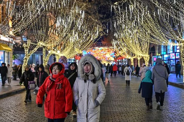 People walk along a street ahead of the annual Harbin Ice and Snow World festival in Harbin