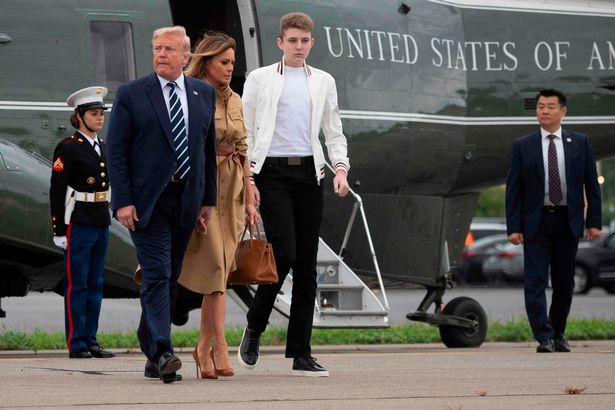 Barron pictured with her parents while getting off a plane