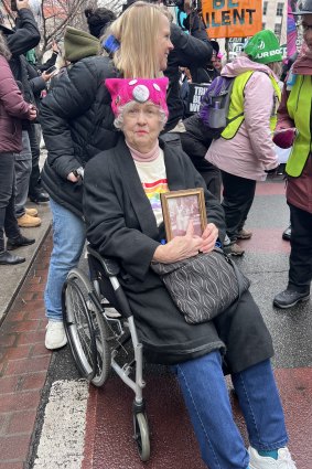 Lida Jones carrying the old, framed photo of her with her maid.