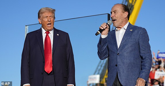 FILE - Republican presidential nominee former President Donald Trump, left, listens to Lee Greenwood at a campaign rally, Oct. 5, 2024, in Butler, Pa. (AP Photo/Evan Vucci, File)