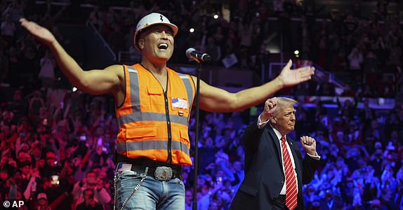 President-elect Donald Trump dances with The Village People at a rally ahead of the 60th Presidential Inauguration, Sunday, Jan. 19, 2025, in Washington. (AP Photo/Evan Vucci)