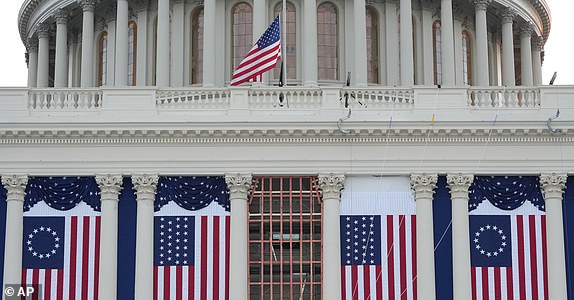 FILE - Flags hang in place on the West Front of the U.S. Capitol ahead of President-elect Donald Trump's upcoming inauguration, in Washington, Jan. 12, 2025. (AP Photo/Jon Elswick, File)