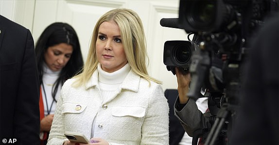 White House press secretary Karoline Leavitt watches as President Donald Trump signs executive orders in the Oval Office of the White House, Monday, Jan. 20, 2025, in Washington. (AP Photo/Evan Vucci)