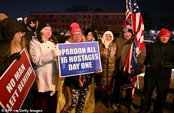 Family and friends of imprisoned participants of the January 6, 2021 riot on the US Capitol, hold signs as they wait outside the DC Central Detention Facility in Washington, DC, on January 20, 2025. US President Donald Trump signed pardons on January 20 for some 1,500 participants in the January 6, 2021 riot at the US Capitol by his supporters who attempted to overturn the 2020 election. (Photo by ROBERTO SCHMIDT / AFP) (Photo by ROBERTO SCHMIDT/AFP via Getty Images)