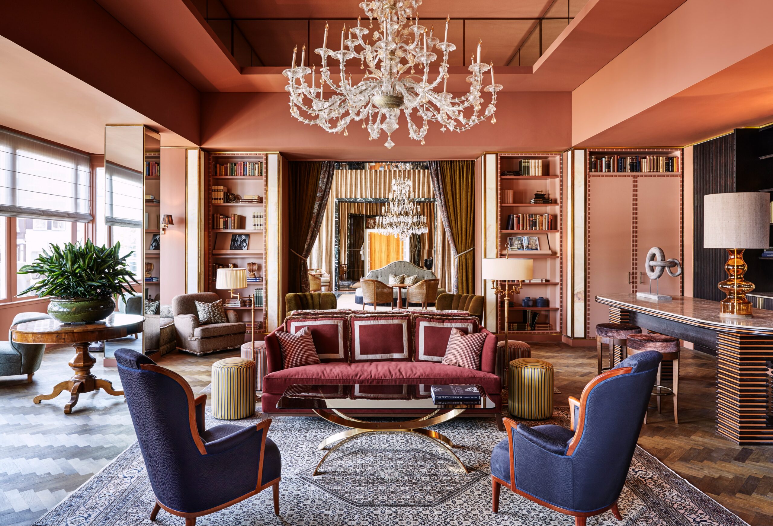 Luxurious hotel lobby with burgundy sofa and armchairs.